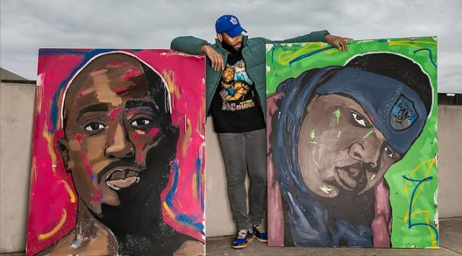 Willie Austin standing between the 2Pac and Biggie portraits under an overpass