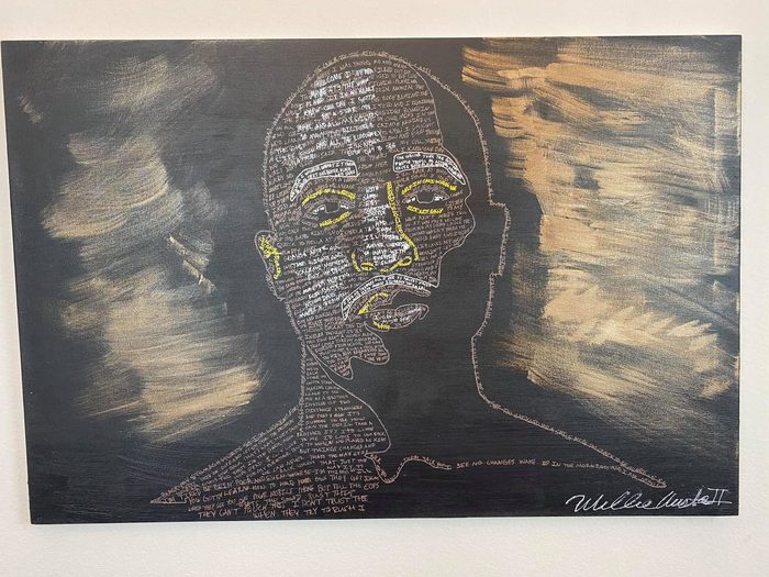 Word portrait, a face outlined in white on a black canvas, filled with handwritten lyrics and framed by strokes of gold