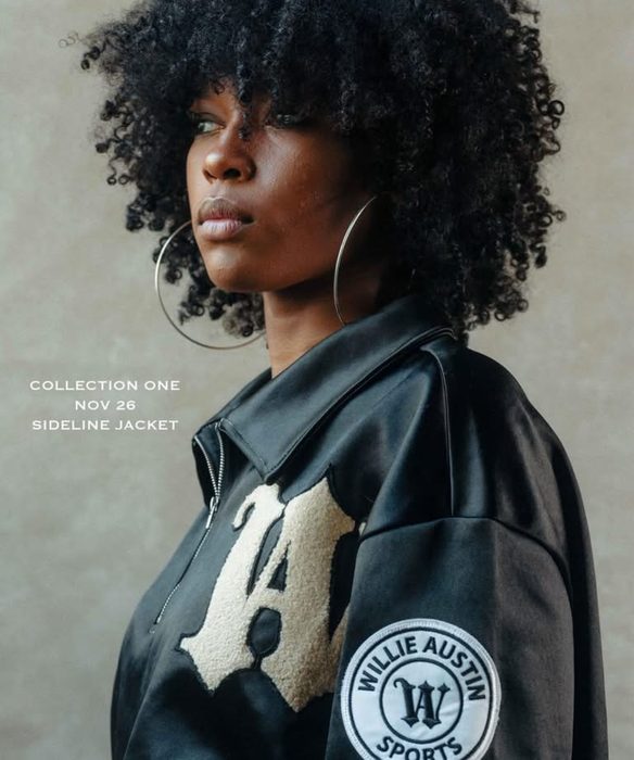 A model in profile wearing the black Willie Austin Sideline Jacket with a cream W, beside the words Collection One, Nov 26, Sideline Jacket