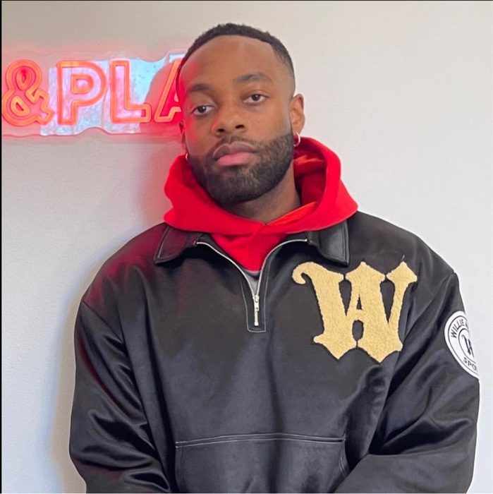 Willie Austin in the black Willie Austin quarter zip with a cream W, over a red hoodie